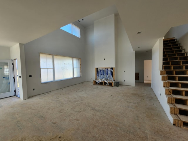 unfurnished living room featuring a high ceiling