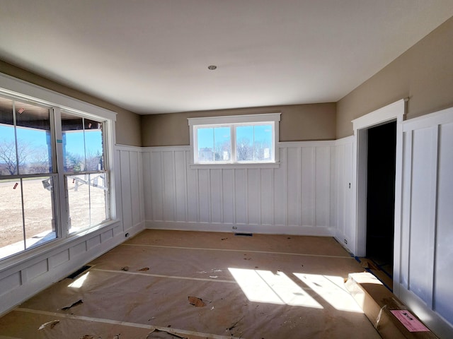 empty room featuring a wainscoted wall and visible vents