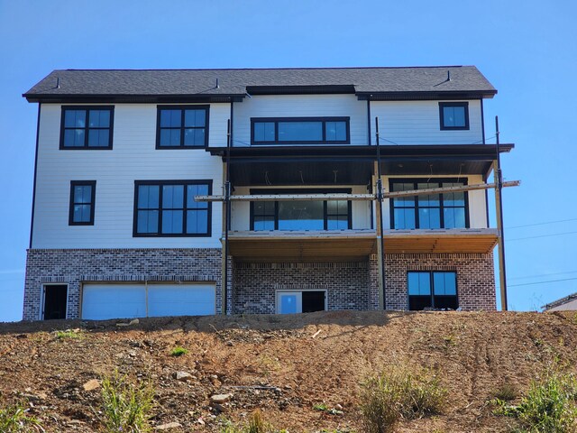 rear view of house with a garage and a balcony