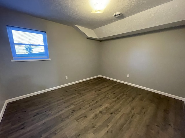 bonus room with a textured ceiling, dark wood-type flooring, and lofted ceiling