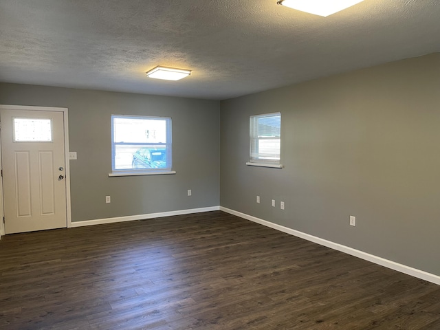 foyer with a textured ceiling and dark wood-type flooring