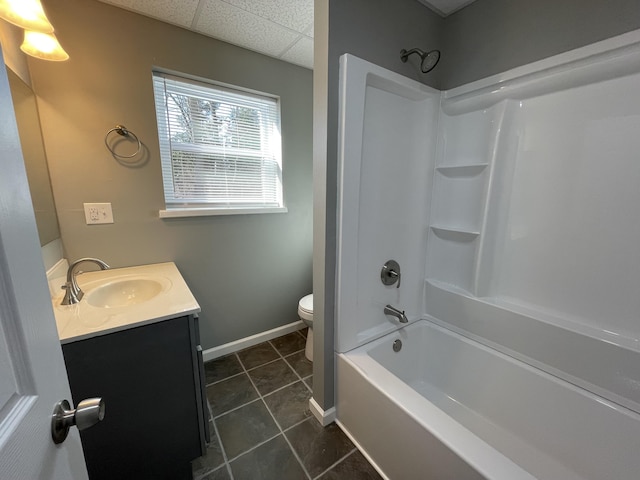 full bathroom featuring a paneled ceiling, tile patterned floors, vanity, shower / washtub combination, and toilet