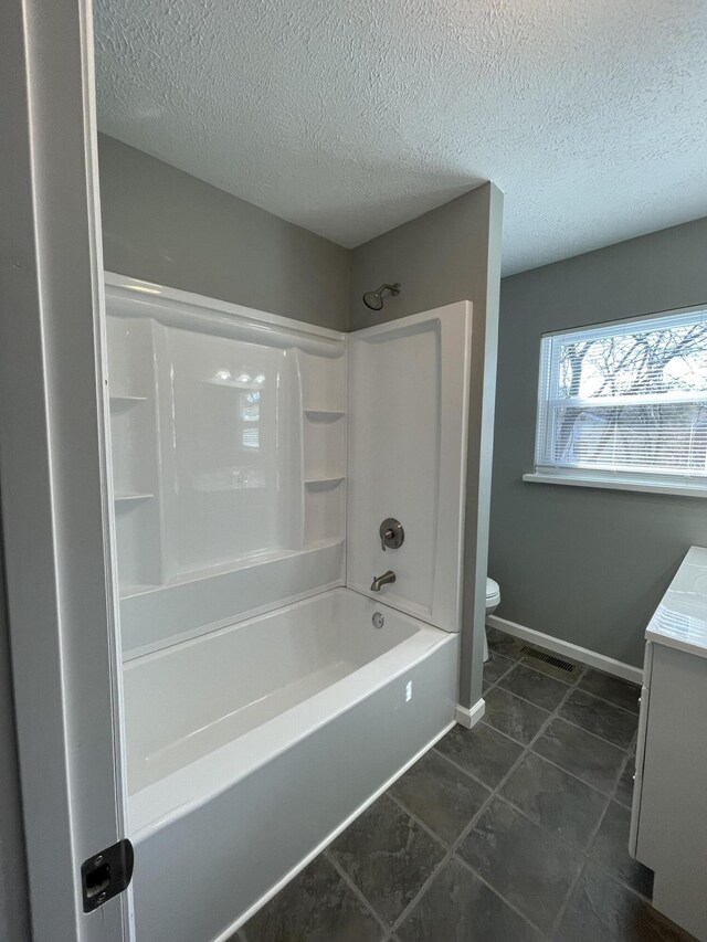 full bathroom with vanity, toilet, washtub / shower combination, and a textured ceiling