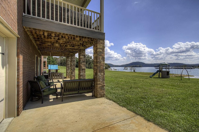 view of patio / terrace with an outdoor living space, a playground, and a water and mountain view