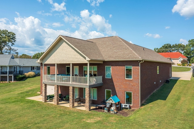 rear view of house with a yard, a balcony, and a patio