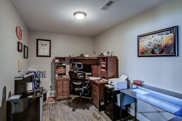 office space featuring a textured ceiling and light hardwood / wood-style flooring