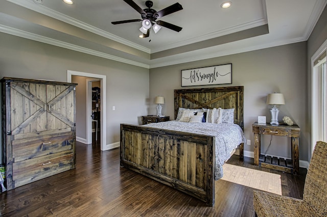 bedroom featuring dark wood-type flooring, a tray ceiling, ceiling fan, and crown molding