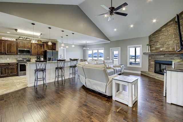 living room with a fireplace, high vaulted ceiling, and dark hardwood / wood-style floors