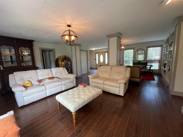 living room with a chandelier, a textured ceiling, and dark hardwood / wood-style floors