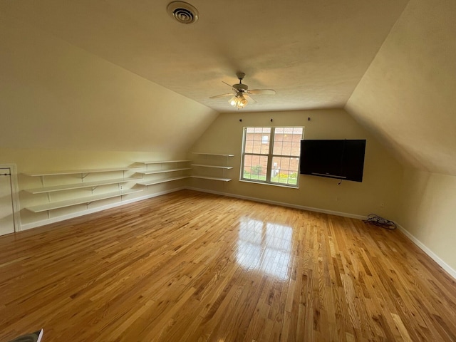 additional living space featuring light hardwood / wood-style flooring, ceiling fan, and lofted ceiling