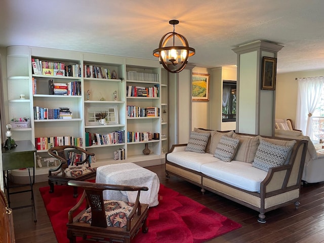 sitting room with dark wood-type flooring, a chandelier, and a textured ceiling