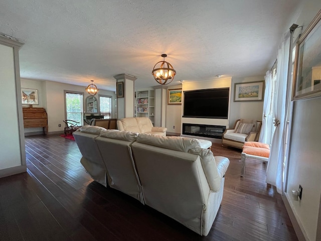 living room with a notable chandelier, dark hardwood / wood-style flooring, and a textured ceiling