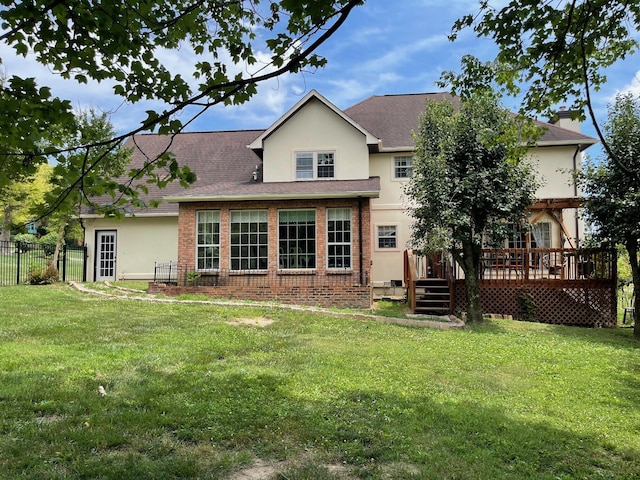 rear view of house with a lawn and a wooden deck