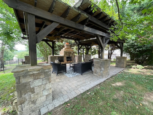 view of patio with a gazebo and an outdoor stone fireplace