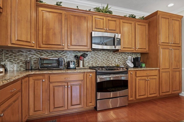 4018 Eagles Nest Dr, Morristown, TN 37813 - kitchen featuring appliances with stainless steel finishes, brown cabinetry, dark wood-style floors, crown molding, and backsplash