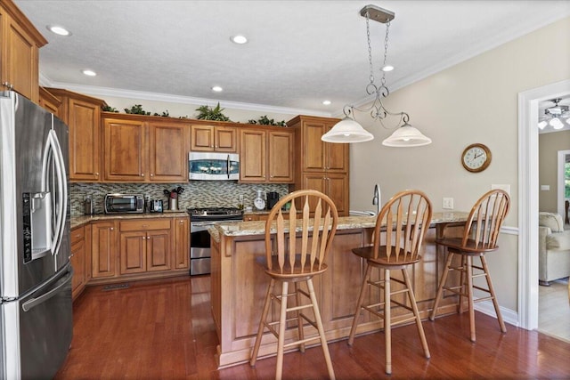 4018 Eagles Nest Dr, Morristown, TN 37813 - kitchen featuring stainless steel appliances, brown cabinetry, tasteful backsplash, light stone countertops, and dark wood-style floors