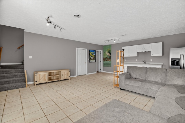 792 Hopper Blf, Rutledge, TN 37861 - living area with rail lighting, stairs, light tile patterned flooring, and a textured ceiling