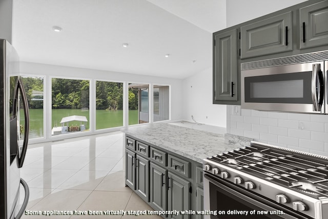 792 Hopper Blf, Rutledge, TN 37861 - kitchen with appliances with stainless steel finishes, vaulted ceiling, tasteful backsplash, light stone countertops, and light tile patterned floors