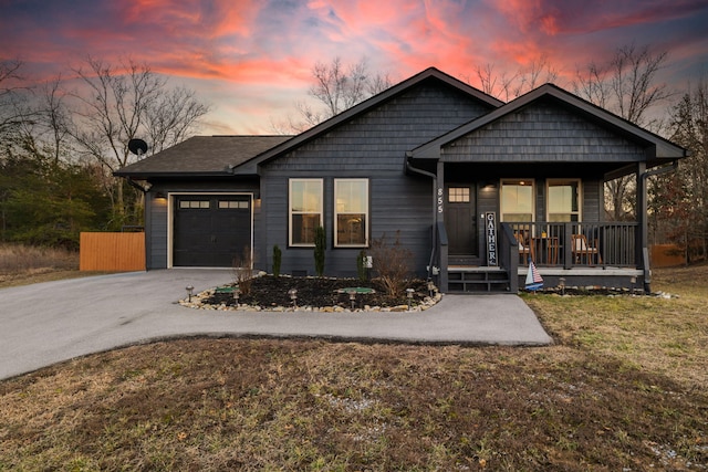 view of front facade featuring a garage, a yard, and covered porch