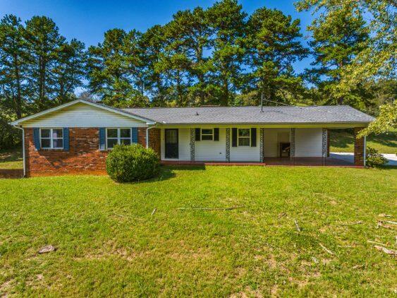 ranch-style house with a front lawn and covered porch