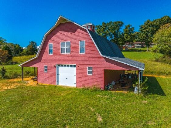 view of property exterior featuring a lawn, an outbuilding, and a garage