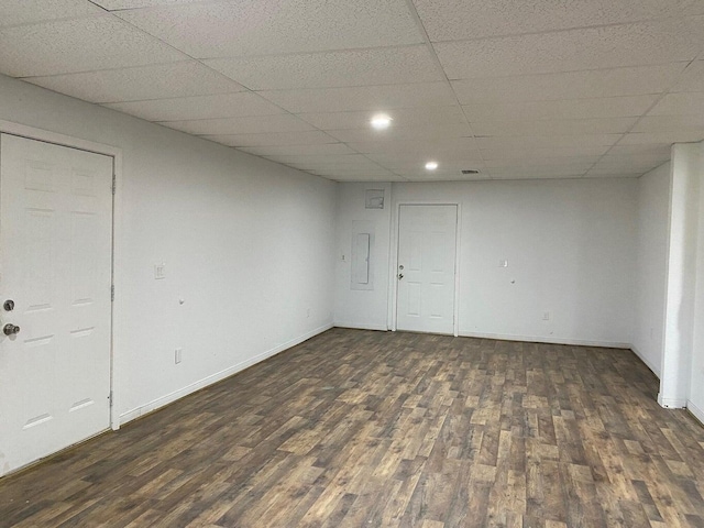 interior space featuring electric panel, dark wood-type flooring, and a paneled ceiling