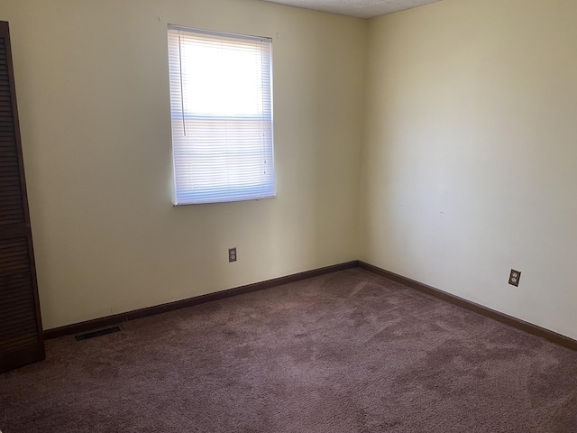 carpeted empty room with visible vents and baseboards