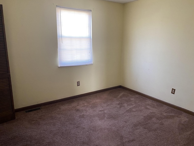 carpeted empty room with visible vents and baseboards