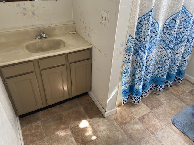 full bath with baseboards, vanity, and a shower with curtain