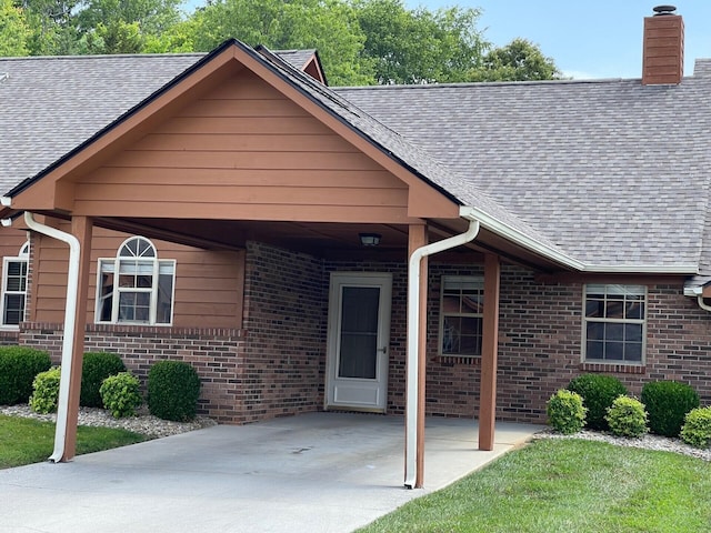 1412 Secreretariat Dr, Morristown, TN 37814 - view of front of property with roof with shingles, brick siding, an attached carport, a chimney, and concrete driveway