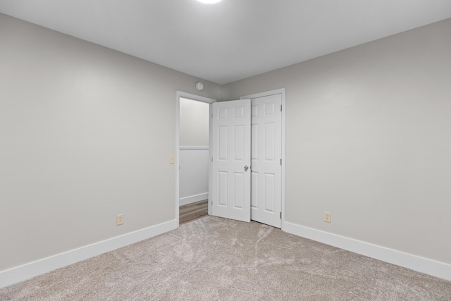 unfurnished bedroom featuring carpet floors, a closet, and baseboards