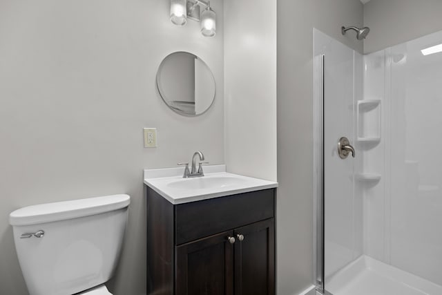 bathroom featuring a stall shower, vanity, and toilet