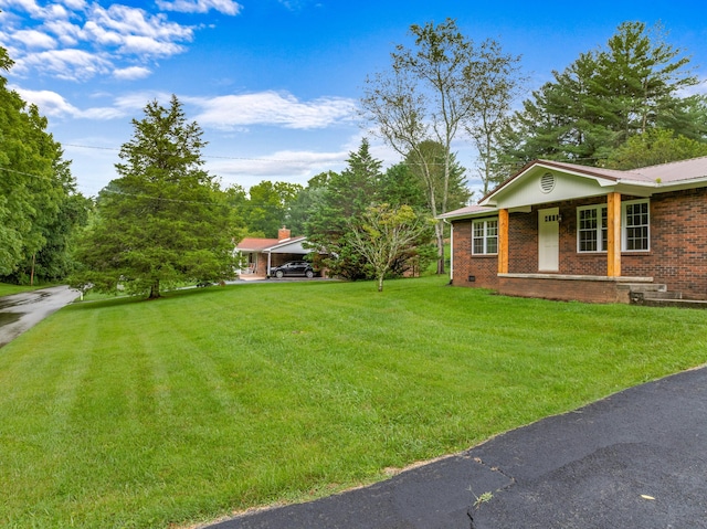view of yard featuring covered porch and a carport