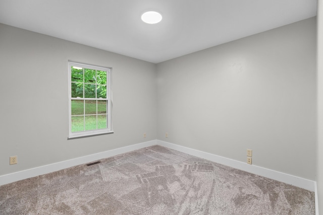 carpeted empty room featuring visible vents and baseboards