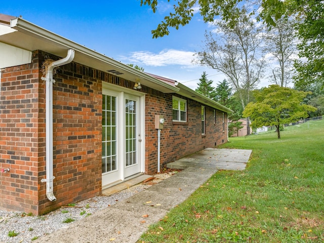 view of home's exterior featuring a lawn and brick siding