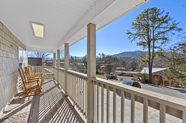 balcony with covered porch and a mountain view