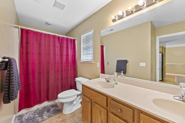 bathroom featuring toilet, tile patterned floors, vanity, and curtained shower