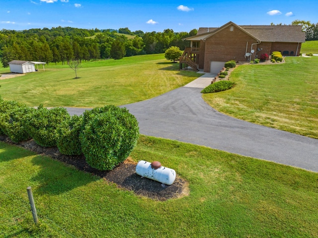 5704 Long Creek Rd, Morristown, TN 37813 - view of green lawn featuring driveway, an attached garage, a storage unit, and stairway