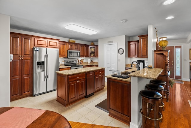 5704 Long Creek Rd, Morristown, TN 37813 - kitchen featuring stainless steel appliances, a peninsula, recessed lighting, light stone counters, and a breakfast bar area