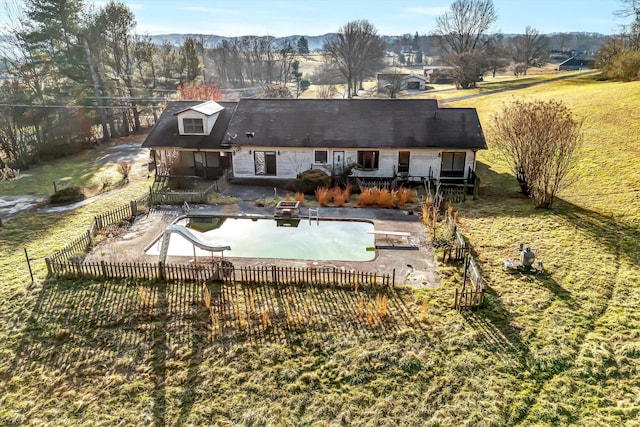 back of house featuring a fenced in pool, a yard, and a patio area