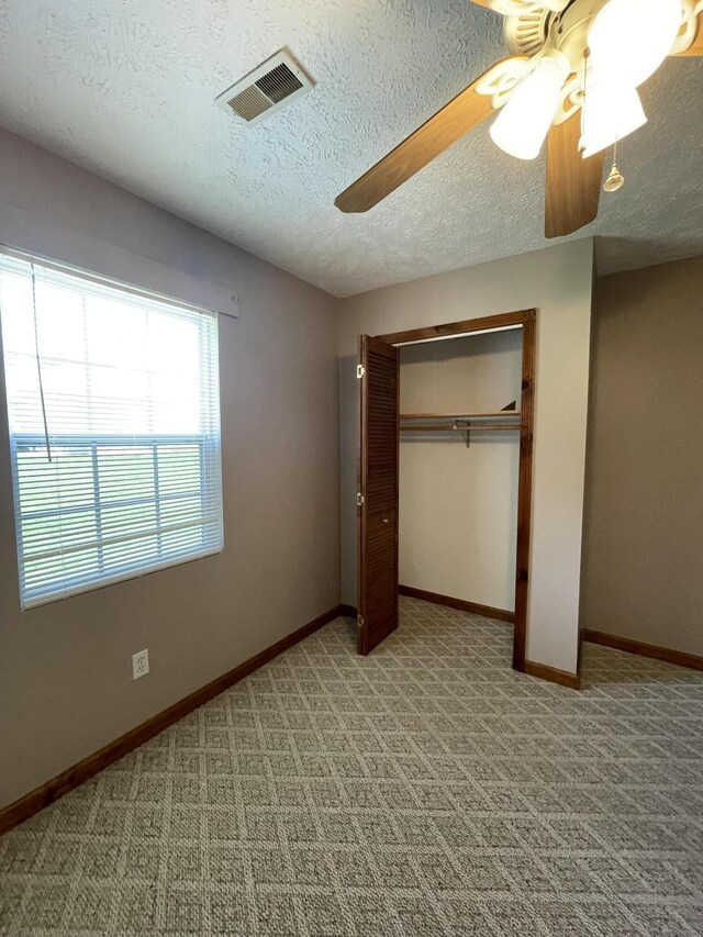 1830 Pheasant Crossing Dr, Dandridge, TN 37725 - unfurnished bedroom with a textured ceiling, light colored carpet, ceiling fan, and a closet