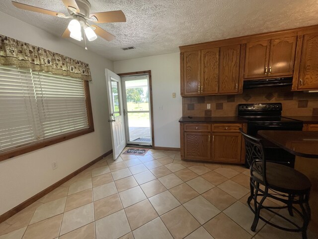 1830 Pheasant Crossing Dr, Dandridge, TN 37725 - kitchen with black electric range, brown cabinets, dark countertops, and a textured ceiling