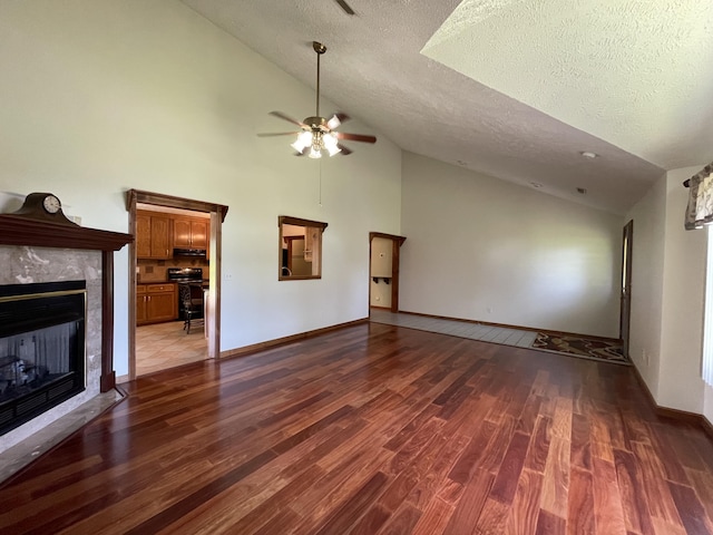 1830 Pheasant Crossing Dr, Dandridge, TN 37725 - unfurnished living room with vaulted ceiling, a ceiling fan, a fireplace, wood finished floors, and a textured ceiling