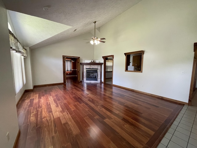 1830 Pheasant Crossing Dr, Dandridge, TN 37725 - unfurnished living room featuring lofted ceiling, a fireplace, ceiling fan, wood finished floors, and a textured ceiling