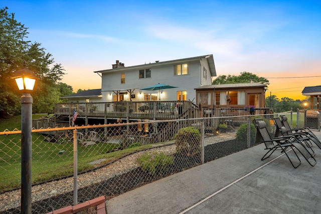 1216 Winding Dr, Sevierville, TN 37876 - back of house at dusk featuring a chimney and a wooden deck