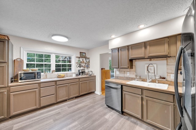 1216 Winding Dr, Sevierville, TN 37876 - kitchen featuring appliances with stainless steel finishes, a sink, a textured ceiling, light countertops, and light wood-style flooring