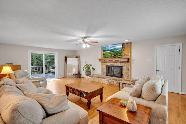 1216 Winding Dr, Sevierville, TN 37876 - living area featuring ceiling fan, a fireplace, light wood-type flooring, and a textured ceiling