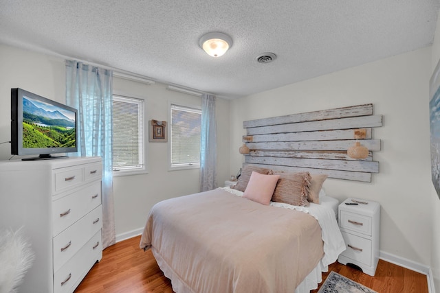 1216 Winding Dr, Sevierville, TN 37876 - bedroom with a textured ceiling, light wood-style floors, and baseboards