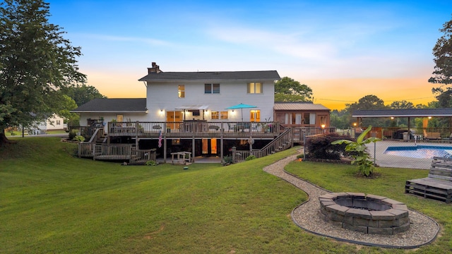 1216 Winding Dr, Sevierville, TN 37876 - back of property at dusk with an outdoor fire pit, a deck, stairway, and a yard