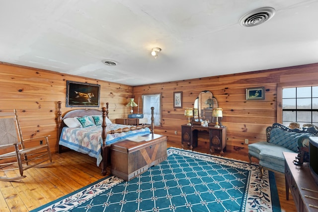 bedroom featuring wood-type flooring and wood walls